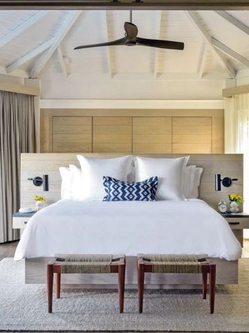 Geräumiges Schlafzimmer mit eleganter Bettwäsche und Holzdach