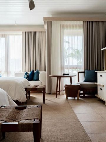 Modern eingerichtetes Zimmer mit zwei Betten und Sitzbereich