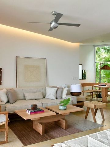 Helles Wohnzimmer mit großen Fenstern und stilvollen Möbeln.