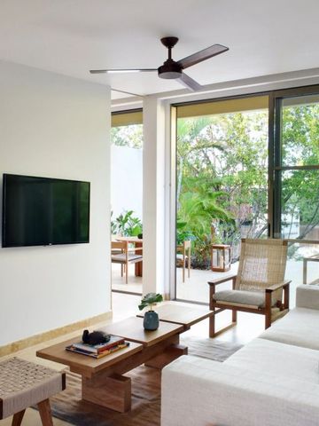 Modernes Wohnzimmer mit TV und Blick auf eine private Terrasse.