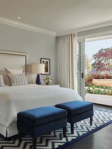 Helles Hotelzimmer mit Blick auf einen grünen Innenhof und eleganter Einrichtung