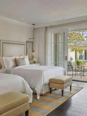 Hotelzimmer mit zwei großen Betten und Zugang zur Terrasse