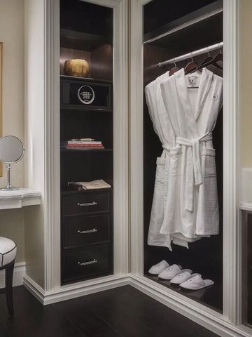 Luxuriöser Ankleidebereich mit Spiegel und Bademänteln im Schrank