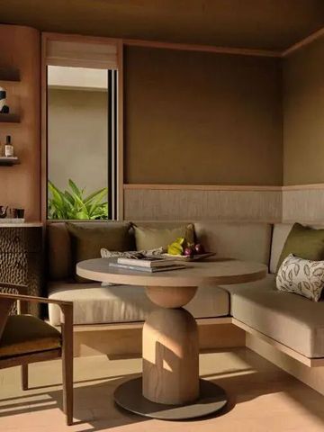 Gemütlicher Sitzbereich mit Tisch und Stühlen in Erdtönen.