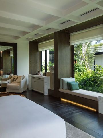 Helles Zimmer mit großem Fenster und Blick auf den grünen Garten.