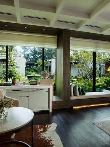 Lichtdurchflutetes Zimmer mit großer Fensterfront und Blick ins Grüne