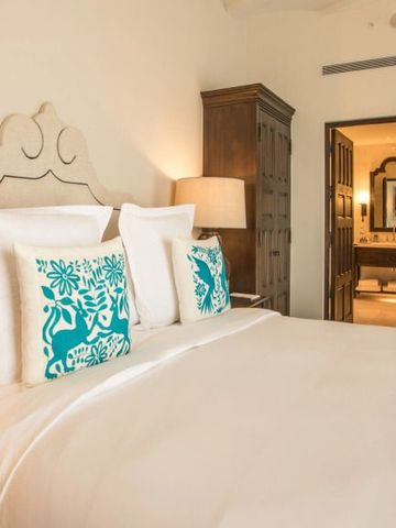 Gemütliches Hotelzimmer mit dekorativen Kissen und Blick ins Badezimmer