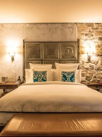 Gemütliches Zimmer mit rustikalen Steinwänden und edler Bettwäsche