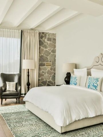 Geräumiges Schlafzimmer mit großem Fenster und gemütlichem Sessel