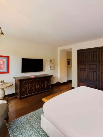 Elegantes Hotelzimmer mit rustikalem Mobiliar und modernem Fernseher