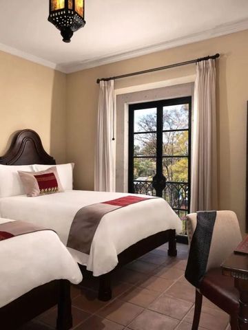 Hotelzimmer mit zwei Betten, traditioneller Einrichtung und Aussicht.