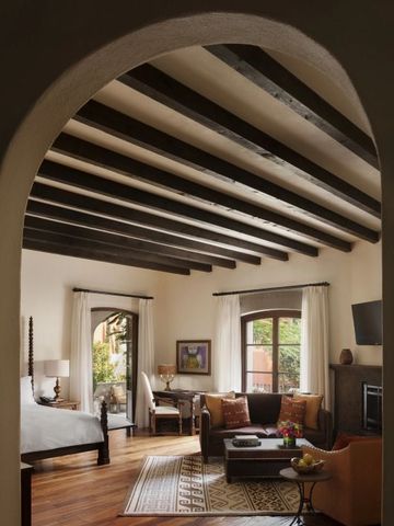 Geräumige Suite mit Holzbalkendecke und stilvoller Einrichtung.