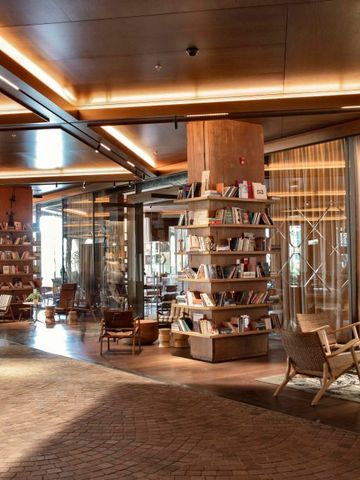 Stilvolle Bibliothek mit Regalen voller Bücher und gemütlichen Sitzmöglichkeiten