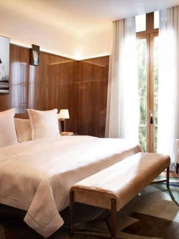 Elegantes Schlafzimmer mit modernem Kunstwerk und großen Fenstern