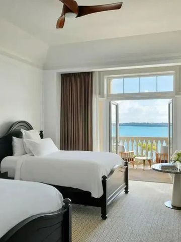 Elegantes Hotelzimmer mit zwei Betten und Balkon mit Meerblick