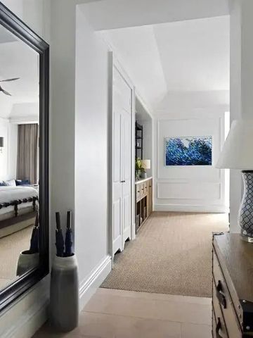 Heller Hotelflur mit dekorativen Elementen und Blick ins Schlafzimmer