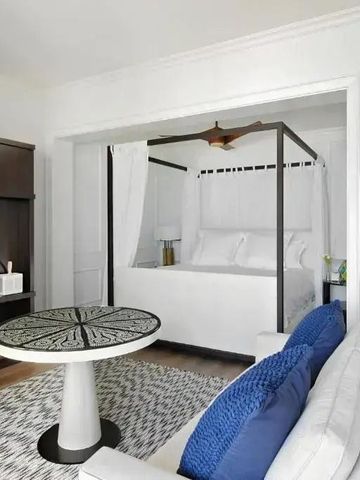 Helles Zimmer mit stilvoller Sitzgelegenheit und Himmelbett