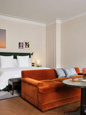 Geräumiges Hotelzimmer mit luxuriösem Sofa und elegantem Bett, stilvolle Dekoration.