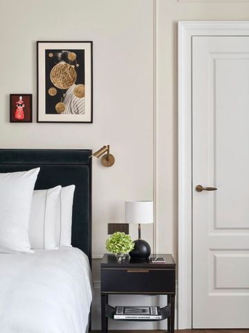 Elegantes Hotelzimmer mit stilvollem Nachttisch und moderner Kunst an der Wand