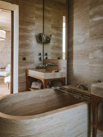 Luxuriöses Badezimmer mit Naturstein und großen Spiegeln