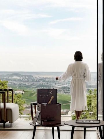 Person in Bademantel mit Blick auf die Weinberge