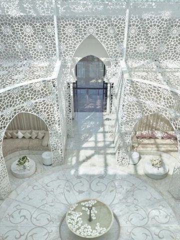 Lichtdurchfluteter Innenhof mit kunstvollen weißen Mustern im Royal Mansour Marrakech
