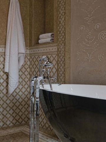 Luxuriöses Badezimmer mit dekorativen Fliesen und eleganter freistehender Badewanne