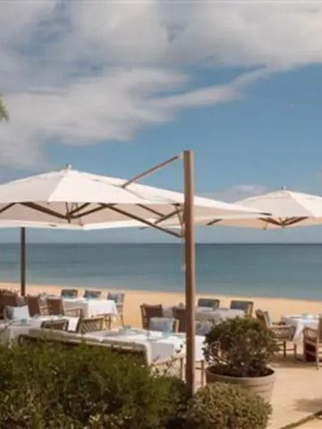 Strandrestaurant mit Sonnenschirmen und Meerblick