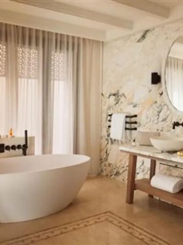 Modernes Badezimmer mit freistehender Badewanne und Marmorwänden