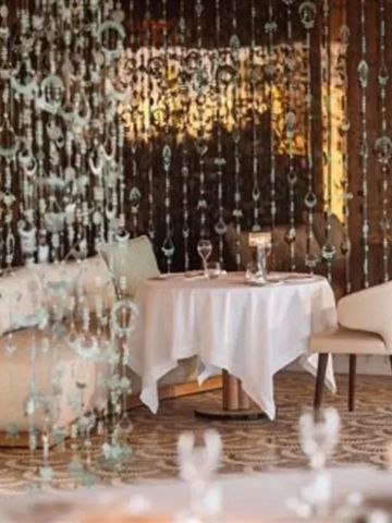 Elegantes Restaurant mit dekorativen Vorhängen und Kerzenbeleuchtung