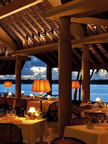 Romantisches Restaurant am Wasser bei Abenddämmerung mit gedämpfter Beleuchtung