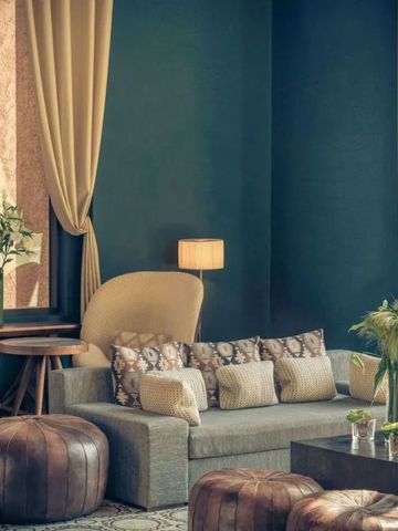 Gemütliche Lounge mit komfortablen Sofas und Poufs in warmen Farben