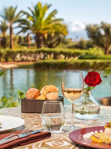 Tisch mit Wein und Speisen am Wasser mit Palmen im Hintergrund