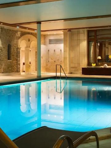 Innenpool mit stilvollem Ambiente und Liegen im Hotel