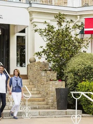 Paar bei einem Spaziergang vor dem eleganten Hoteleingang