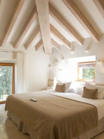 Zimmer mit Holzbalkendecke und großem Doppelbett