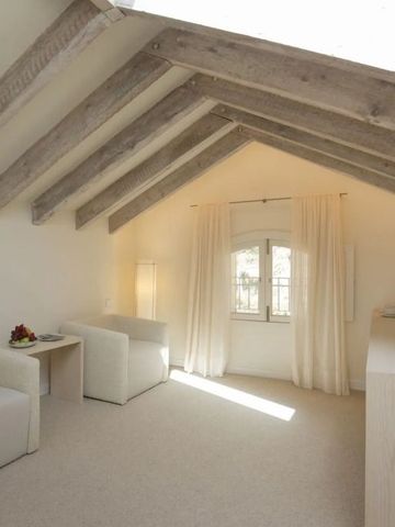 Wohnbereich mit sichtbaren Holzbalken und gemütlichen Sofas