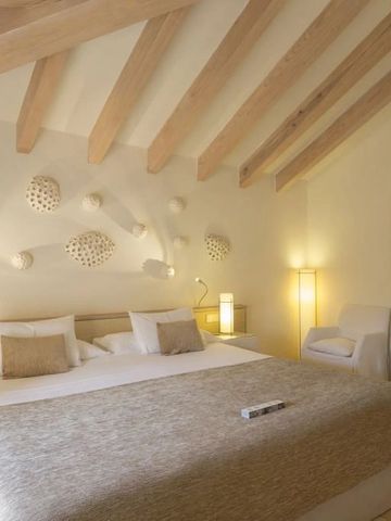 Elegantes Doppelzimmer mit Holzbalkendecke und stilvoller Kunst an der Wand