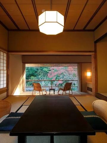 Gemütliches Zimmer mit Tatami und Blick auf herbstliche Landschaft