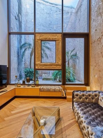 Moderne Lounge mit hohen Fenstern und dezenter Dekoration im Sa Creu Nova Hotel.