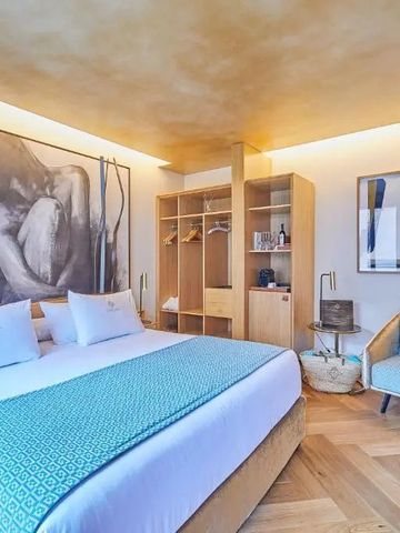 Modernes Hotelzimmer mit Holzfußboden und stilvoller Kunst an der Wand