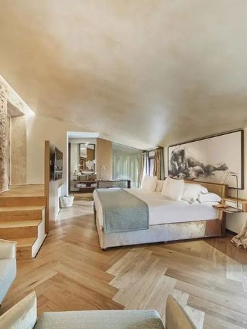 Geräumiges Hotelzimmer mit Steinakzenten und luxuriösem Bett