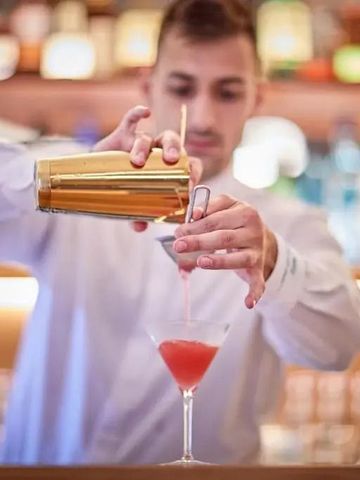 Barkeeper beim Mixen eines Cocktails an einer stilvollen Bar