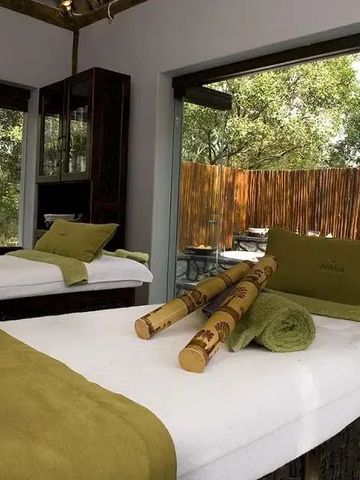 Wellnessraum mit zwei Massageliegen und Blick ins Grüne