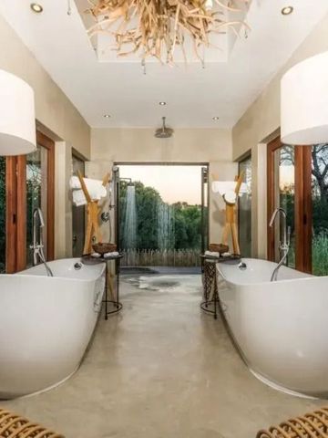 Luxuriöses Badezimmer mit zwei freistehenden Badewannen und Naturblick