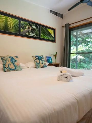 Schlafzimmer mit Doppelbett, Naturdekor und Glastür zur Terrasse