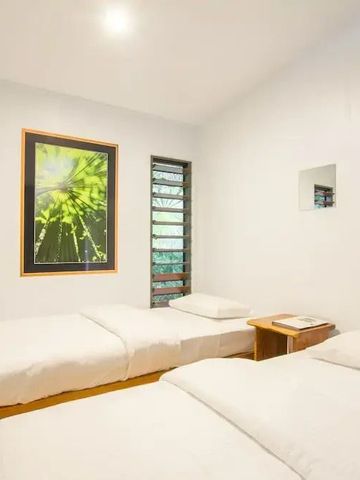 Helles Zimmer mit zwei Einzelbetten und Pflanzenmotiven an der Wand