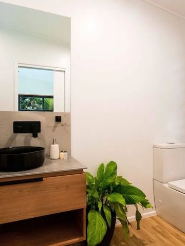 Modernes Badezimmer mit Pflanzen und hölzernem Waschtisch