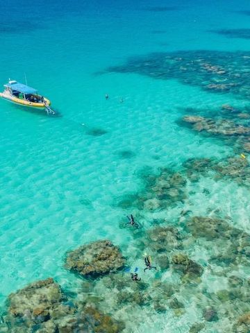 Türkisfarbenes Wasser mit Schnorchlern und Boot