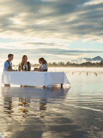 Tisch auf ruhigem Wasser mit malerischem Ausblick und Abendessen